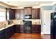 Well-equipped kitchen features wooden cabinetry, tile backsplash, granite counters and stainless steel appliances at 611 Winners Cir, Locust Grove, GA 30248