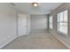 Bedroom with neutral carpet, two windows, and a white door at 656 Sunset Park Dr, Suwanee, GA 30024