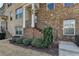 Charming brick townhome entrance with landscaped front yard and iron railing at 656 Sunset Park Dr, Suwanee, GA 30024