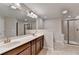 Main bathroom showcasing double sinks, tile flooring, and glass shower at 656 Sunset Park Dr, Suwanee, GA 30024