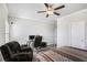 Neutral bedroom with a ceiling fan, desk, chair, and striped bedspread at 1604 Falcon Ct, Locust Grove, GA 30248