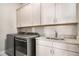 Functional laundry room with modern appliances, granite countertops, and ample cabinet space at 1604 Falcon Ct, Locust Grove, GA 30248