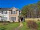 Charming two-story townhouse with brick facade, landscaped front yard, and walkway to covered porch at 217 Odyssey Turn Nw, Conyers, GA 30012