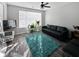 Bright living room featuring hardwood floors, a dark sofa, and a large window with natural light at 217 Odyssey Turn Nw, Conyers, GA 30012