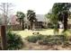Spacious backyard with lush greenery, mature palm trees, and a cozy patio area at 1313 Idlewood Ct, Mcdonough, GA 30252