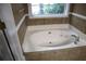 Close-up of garden tub with tile surround and window at 1313 Idlewood Ct, Mcdonough, GA 30252