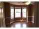 Bedroom featuring three windows providing natural light and hardwood flooring at 1313 Idlewood Ct, Mcdonough, GA 30252