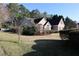 A view of a two-story home with brick exterior and a well-manicured lawn surrounded by trees at 1313 Idlewood Ct, Mcdonough, GA 30252