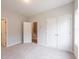 Bright bedroom featuring plush carpeting, closet, and a doorway leading to the staircase at 1923 Deco Dr, Kennesaw, GA 30144