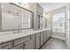 Luxurious bathroom boasting double sinks, marble countertops, gray cabinets, and a glass-enclosed shower at 513 Broadview Ln, Atlanta, GA 30324