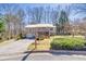 Split-level home with metal roof, front porch, and manicured landscaping in a wooded neighborhood at 3016 Ansley Manor Ct, Snellville, GA 30078