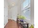Bright hallway featuring hardwood floors, a window with blinds, and a decorative table with plants at 5711 Keys Way, Lithonia, GA 30058
