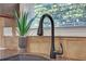 Close-up of a modern kitchen sink with a sleek, matte black faucet and granite countertops at 5711 Keys Way, Lithonia, GA 30058