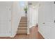 Carpeted staircase ascending to the upper level, illuminated by natural light, framed by white walls and doors at 5711 Keys Way, Lithonia, GA 30058