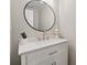 Updated powder room vanity with marble countertop, sleek faucet, and round mirror. Neutral, modern decor at 1230 Newbridge Ne Trce, Brookhaven, GA 30319