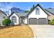Charming traditional home featuring a 2-car garage, a manicured lawn, and a classic white stucco facade with black trim at 1230 Newbridge Ne Trce, Brookhaven, GA 30319