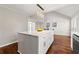Large kitchen island with marble countertops, white cabinetry, and modern pendant lighting. Dining area in background at 1230 Newbridge Ne Trce, Brookhaven, GA 30319