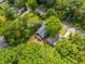 Aerial view of a property surrounded by mature trees, featuring the renovated home and a detached garage at 1321 Bridges Sw Ave, Atlanta, GA 30310