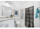 Well-lit bathroom with modern vanity, shower with curtain, and coordinated accessories at 1321 Bridges Sw Ave, Atlanta, GA 30310