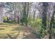 A spacious, grassy backyard bordered by mature trees and natural foliage for privacy at 2149 Shoals Way, Decatur, GA 30034