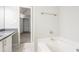 Bright bathroom with white tub, grey countertops, and view into closet at 2149 Shoals Way, Decatur, GA 30034
