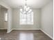 Dining room with wood-look floors, a modern chandelier, neutral paint, and natural light from a window at 2149 Shoals Way, Decatur, GA 30034