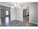 Dining area leading to the kitchen and living room, featuring wood-look floors and a modern chandelier at 2149 Shoals Way, Decatur, GA 30034