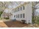 Side view of a white two-story home with black shutters and an attached garage, set on a grassy lot at 2149 Shoals Way, Decatur, GA 30034