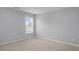 A simple bedroom with light-gray painted walls, neutral carpet, and a window with white blinds at 2393 Strand Ave, Lawrenceville, GA 30043