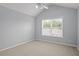 This bedroom offers neutral carpeting, a ceiling fan, and a large window with blinds at 2393 Strand Ave, Lawrenceville, GA 30043