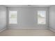 This bedroom has light-gray painted walls, neutral carpet, and two windows with white blinds at 2393 Strand Ave, Lawrenceville, GA 30043