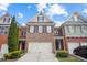 Charming townhome showcasing a brick facade, symmetrical windows, and attached two-car garage at 2393 Strand Ave, Lawrenceville, GA 30043