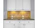 Close-up of kitchen cabinets, granite countertop, and a decorative tile backsplash at 2393 Strand Ave, Lawrenceville, GA 30043