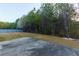 Spacious backyard with a patio, grass, blue fence and natural views to the trees behind the home at 3070 Staglin Dr, Powder Springs, GA 30127