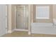 Bright bathroom featuring a separate shower, soaking tub, and a large window for ample natural light at 3070 Staglin Dr, Powder Springs, GA 30127