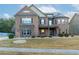 Stunning two-story brick home featuring stone accents and a well-manicured front lawn at 3070 Staglin Dr, Powder Springs, GA 30127