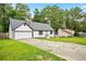 Charming renovated home with a well-manicured front lawn, attached garage, and classic black-and-white color scheme at 3481 Oak Run Dr, Lithonia, GA 30038