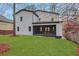 Spacious backyard featuring lush green grass, modern home exterior, and a charming covered porch with outdoor seating at 2497 Wawona Ne Dr, Brookhaven, GA 30319