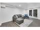 Cozy basement living area with a gray sectional couch, accent chair, and access to outdoor light through glass doors at 2497 Wawona Ne Dr, Brookhaven, GA 30319