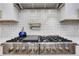 Close-up of a modern range with stainless steel finish and white backsplash at 2497 Wawona Ne Dr, Brookhaven, GA 30319