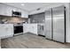 Modern kitchen with stainless steel appliances, white cabinets, gray backsplash, and wood-look flooring at 2497 Wawona Ne Dr, Brookhaven, GA 30319