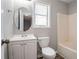 Bathroom with white vanity, toilet, and tub/shower combination, complemented by a window at 6265 Stoney Cv, Austell, GA 30168