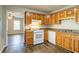 Kitchen with wood cabinets, laminate counters, tile backsplash, and wood-look floors at 6265 Stoney Cv, Austell, GA 30168