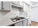 Kitchen features stainless steel sink, shaker cabinets and views to an adjacent room at 838 Lake Hollow Sw Blvd, Marietta, GA 30064