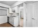Kitchen with double basin sink, dishwasher, white cabinetry, and bi-fold doors at 838 Lake Hollow Sw Blvd, Marietta, GA 30064