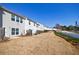 Backyard view of a row of townhomes, showcasing a spacious, grassy area and white fence at 2873 Snapfinger Mnr, Decatur, GA 30035