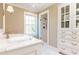 Bright bathroom with marble vanity, glass enclosed shower, built-in storage, and patterned wallpaper at 2980 Bakers Meadow Se Ln, Atlanta, GA 30339