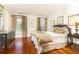 Comfortable bedroom featuring hardwood floors, neutral walls, framed art, and windows dressed with patterned draperies at 2980 Bakers Meadow Se Ln, Atlanta, GA 30339