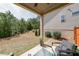 Covered outdoor patio featuring comfortable seating and a treelined yard at 307 Serenity Way, Woodstock, GA 30188