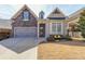 Charming home exterior with stone accents, a well-manicured lawn, and a welcoming front entrance at 307 Serenity Way, Woodstock, GA 30188